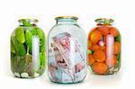 Glass jars with cucumbers tomatoes and money on a white background