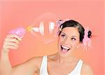 Beautiful happy teenage girl blowing soap bubbles and having fun. pink background