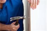 Close-up of a handyman building furniture using a hammer and a nail at home