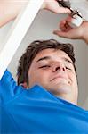 Self-assured man repairing his sink in the kitchen at home