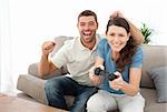 Cheerful man encouraging his girlfriend playing video game at home