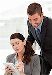 Serious businesswoman taking notes while discussing with her colleague in the office