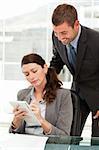 Concentrated woman taking notes whiletalking to her manager in the office