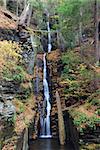 Autumn Waterfall in mountain with foliage and woods over rocks. Silver Thread Falls from Dingmans Falls Pennsylvania.