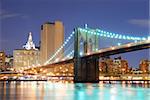 New York City Manhattan skyline and Brooklyn Bridge at dusk over Hudson River with skyscrapers