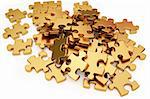 pile of gold puzzle elements scattered on the surface. isolated on white with clipping path.