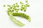 Pod of green peas and small seeds on linen background