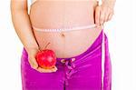 Pregnant woman measuring her belly and holding apple isolated on white. Close-up.