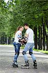 Young couple roller-skating in the park