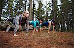 Runners doing push-ups in forest