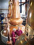 Workers checking stills in distillery