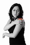 Beautiful woman holding her shoulder with pain and ache,wearing a sporty black tank top, isolated.