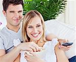 Young couple having fun in front of the TV in ther living-room