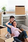adorable couple sitting on the floor in their new house during removal looking the front