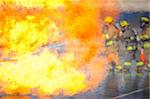 Vagues de chaleur occulter partiellement une équipe de pompiers se prépare à attaquer un feu de formation.