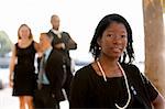 An attractive African American business woman with colleagues in the background