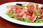 Mixed greens with prosciutto and black mission figs. Shallow dof