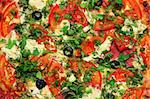 close-up view on pizza with tomatoes and greens