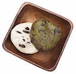 Sliced cherimoya in a wooden bowl  isolated on white with a clipping path.