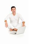 man dressed in white sitting on the floor with laptop