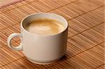 Little white espresso coffee cup on a bamboo mat
