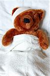 sick teddy bear with injury in a bed in the hospital