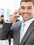 Cheerful businessman on the phone during a meeting with his team in the office