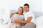 Cute couple resting together on a bed at home