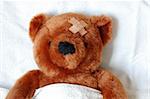 sick teddy bear with injury in a bed in the hospital