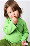 Toddler girl with chubby cheeks wearing a green top