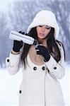 Beautiful woman holding thermos in snowy winter outdoors