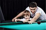 The young father learns the son to play billiards
