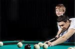 Young father and the son play billiards