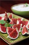 Appetizer consisting of fresh black mission fig wedges with nut and honey cheese dip