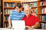 Father and son surfing the internet at the school library.