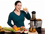Beautiful woman drinking and enjoying a freshly squeezed organic fruit juice made with her juicer in kitchen, isolated.