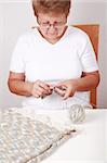 Photo of elderly woman knitting handmade