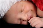 Newborn baby boy wearing a christmas hat