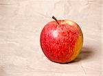 An image of a nice red apple on grunged paper background