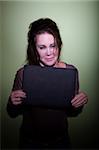 Teary woman with messy hair takes mugshot