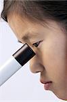 Young Asian girl looking into a microscope