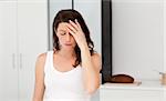 Exhausted woman having a headache in her bathroom at home