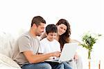 Handsome man showing something on the laptop screen to his family