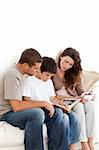 Adorable family looking at a photo album together on the sofa at home