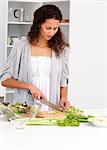 Lovely woman cutting vegetables in the kitchen for a salad