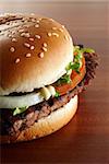 close-up of a delicious hamburger with salad and tomato on wood grain