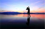 Silhouette of a girl in the water at sunset