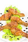 chicken drumstick closeup at white plate with lettuce