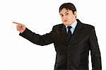 Shocked young businessman pointing  finger in corner  isolated on white