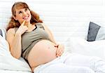 Dreams  beautiful pregnant woman sitting on sofa at home and holding her belly